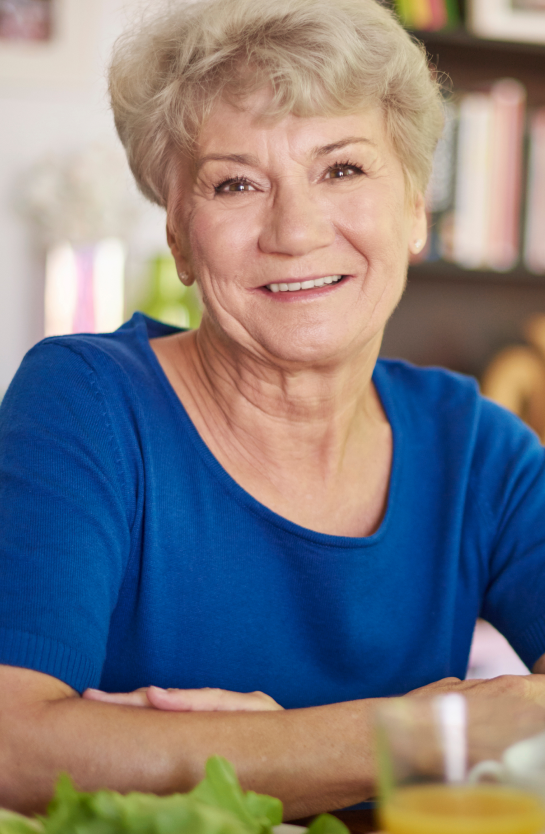 smiling-senior-woman-sitting-at-the-table-FAC3GYZ 1